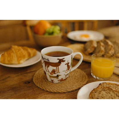 Porseleine mok met hondenillustraties gevuld met thee op een sfeervolle ontbijttafel, perfect voor een warm en ontspannen theemoment.